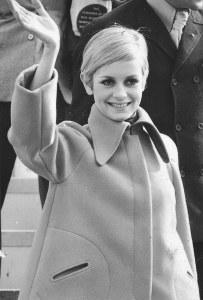 Twiggy arrives at Kennedy International Airport wearing an orange fleece tent coat on March 21, 1967, in New York.